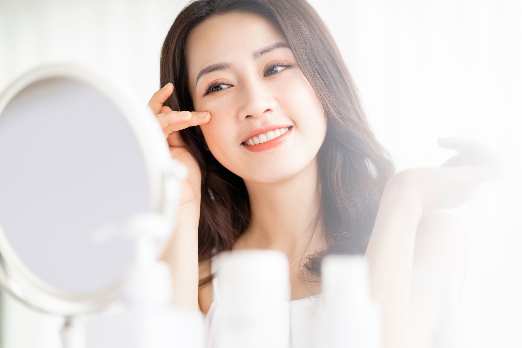 Asian Woman Sitting Makeup in Front of Mirror